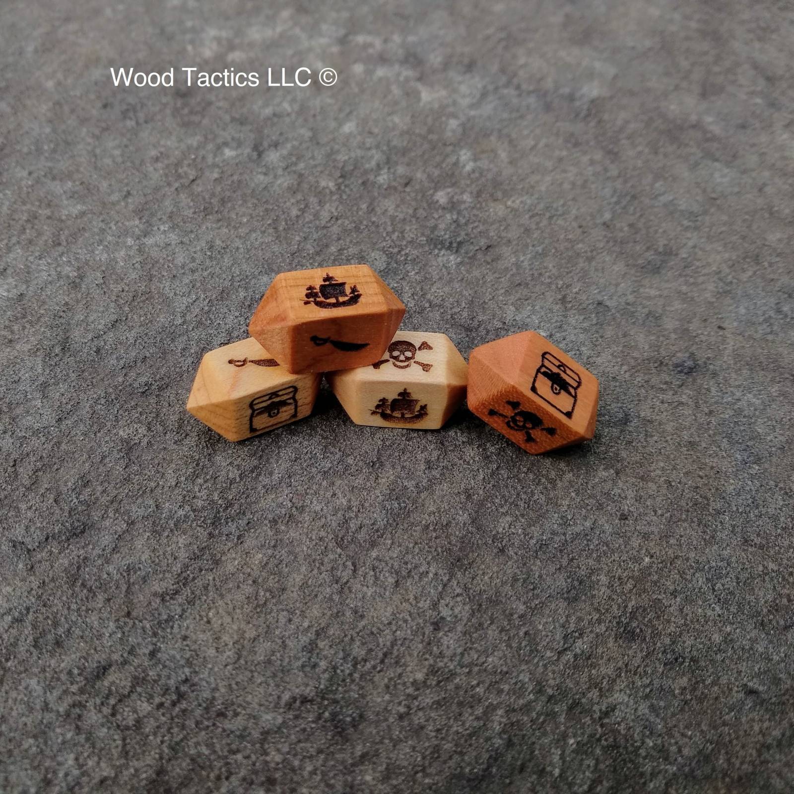 Various Hardwood Barrel D4 dice for the bluffaneer game. Symbols are Pirate Ship, Skull and Pones, Treasure Chest and Sword.