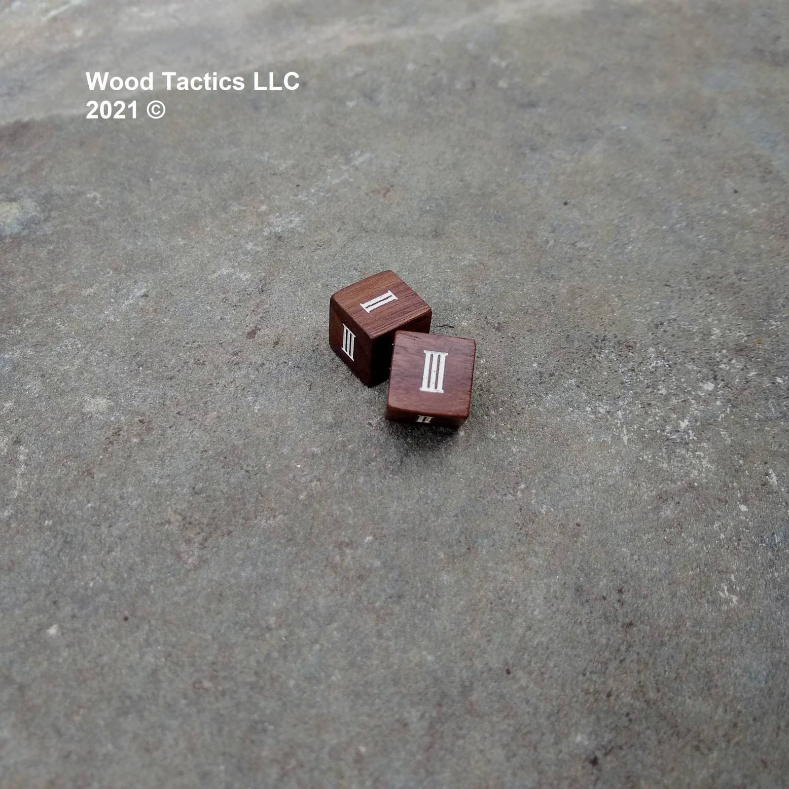 Walnut Hardwood D6 16mm in size Dice with Roman Numerals Symbols. Symbols are inked in white.