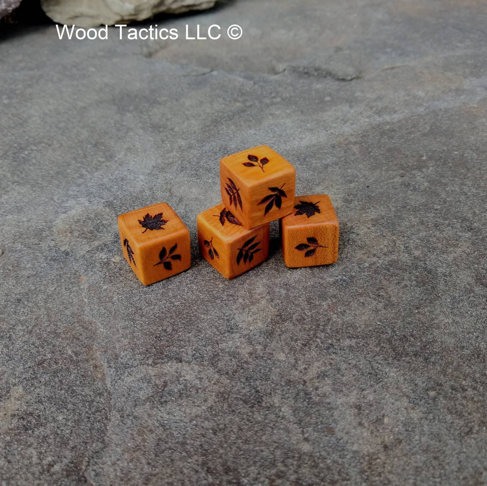 Cherry hardwood d6 dice with intricate tree leaf designs: dogwood, oak, maple, hickory, walnut & cherry leaves.
