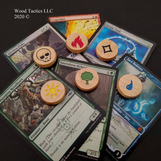 Mana Hardwood Tokens made from Maple and inked, for Magic The Gathering laying on top of magic cards.